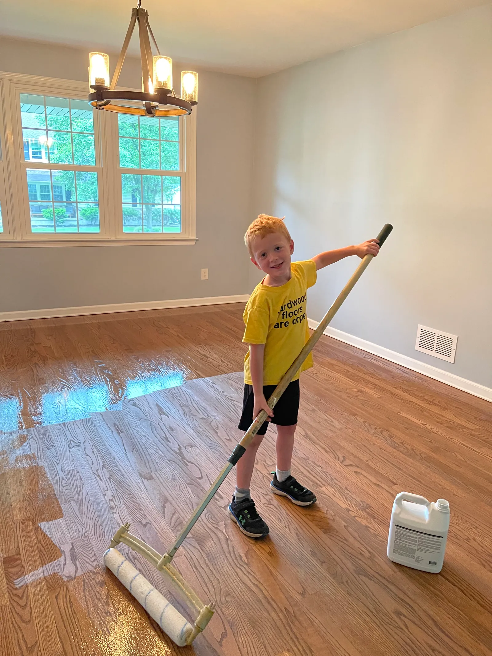 Child helping with floor refinishing - family-friendly workspace