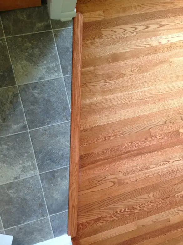 Custom hardwood floor transition piece installed